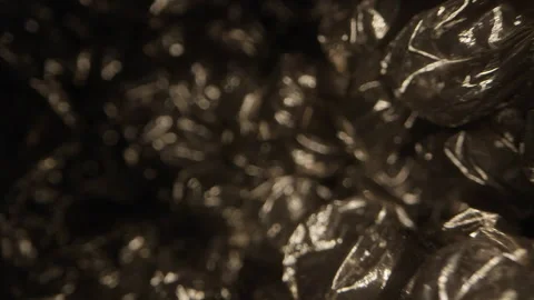 Extreme macro dolly movement over black bubble wrap packaging film with glossy p Video stock 330878197