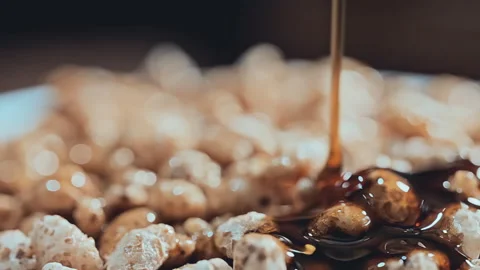 Extreme Macro of Golden Maple Syrup Pouring Over Crispy Puffed Cereal Stock-Footage 341962735