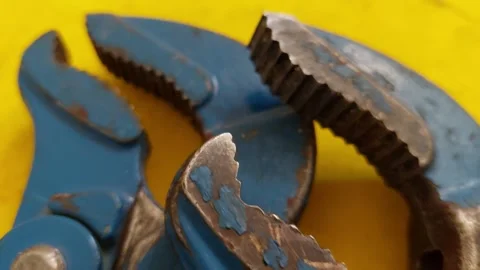 Extreme macro pan shot of the serrated steel jaws and teeth of blue adjustable p Vídeos de archivo 336484564