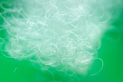 Extreme macro of polyester stable fiber on green background Illustrazione stock