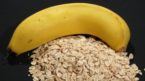 Extreme Macro Rotating Rolled Oats and Banana on Black. Video stock 333045159