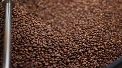 Extreme macro slow motion of roasted coffee beans moving inside a roasting drum. Stock Footage 327394594
