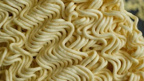 Extreme macro top view of raw instant ramen noodle texture slowly rotating Stock Footage 346688088