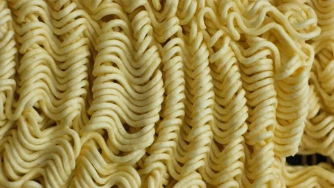 Extreme macro top view of raw instant ramen noodle texture slowly rotating Stock Footage 346883859