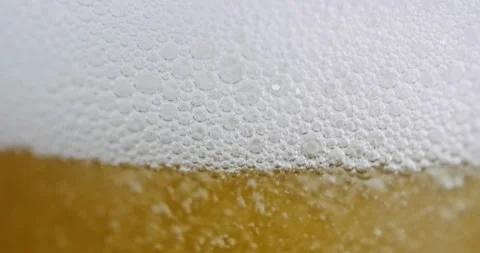 Extreme Macro of White Beer Foam Head and Golden Carbonation Bubbles Stock Footage 342969949