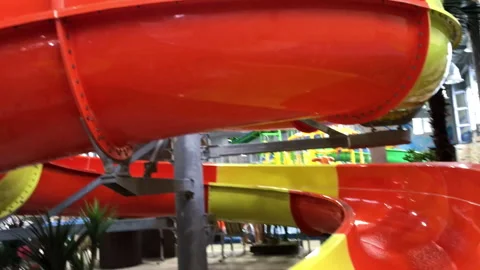 Extreme orange and yellow empty slide with streaming water in water park without Stock Footage 263958417