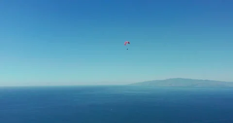 Extreme paraglider flying against a clear blue sky. Stock Footage 141176953