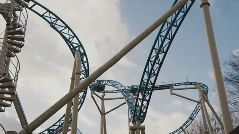 Extreme Ride in Action Roller Coaster Curving Against Dramatic Clouds Stock Footage 307940114