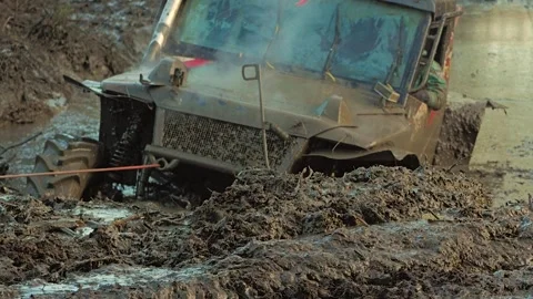 An extreme off-road vehicle is stuck deep in thick mud during an off-road Stock Footage 344876810
