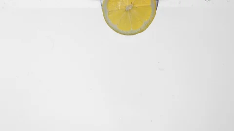 Extreme Slow Mo Of Lemon Slice Falling Into Water Stock Footage 125990297