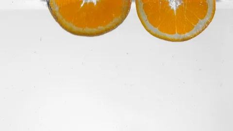Extreme Slow Mo Of Two Orange Slices Falling Into Water Stock Footage 125990428