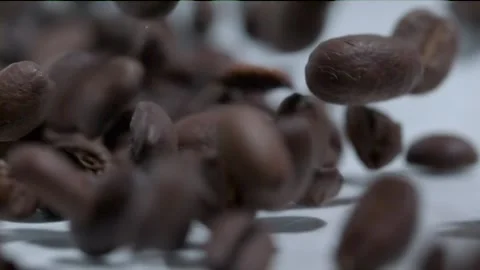 Extreme slow motion coffee beans cascading past the camera lens Stock Footage 145164535
