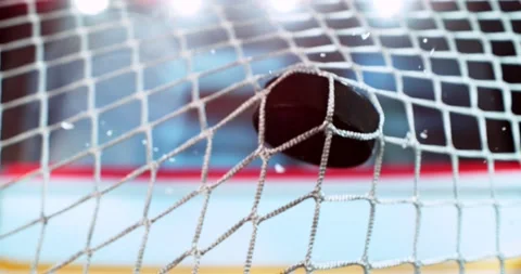 Extreme super slow motion close-up of an ice hockey puck striking the goal net Stock Footage 330424291