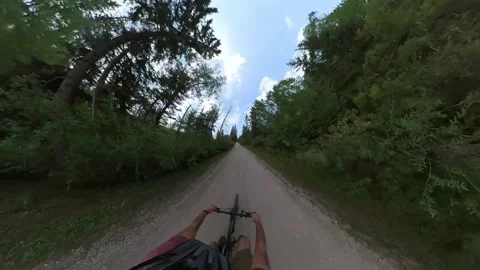 Extreme wide-angle from a cyclist as he is riding along a narrow trail trough an Stock Footage 341835262