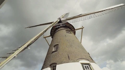 Extreme wide low angle shot of a Dutch windmill spinning on a sunny day Stock Footage 85215751