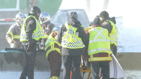 Extreme winds is an extra challenge for cops and paramedics working on victim Video stock 125168616