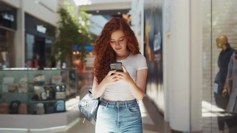 Extremely beautiful cute young redheaded student girl walking down the shopping Stock Footage 114248205