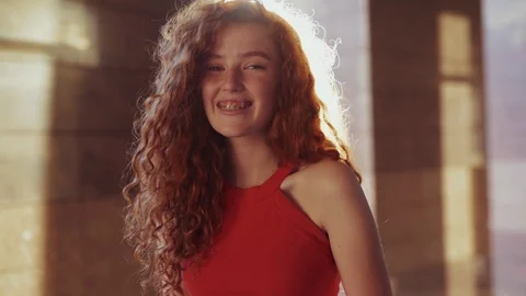 Extremely beautiful red headed curly young Caucasian student girl in trendy red Stock Footage 115669333