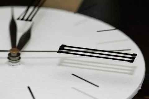 Extremely close-up black clock hands on a white dial, selective focus Stock Photos