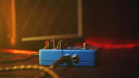 Extremely close up of button for effect electro guitar pedal. Red neon light  Stock Photos
