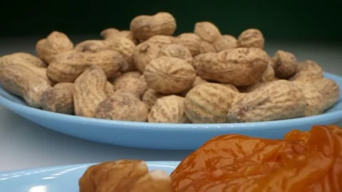 Extremely close-up, detailed. peanuts, dried apricots and walnuts on a blue Stock Footage 147070296