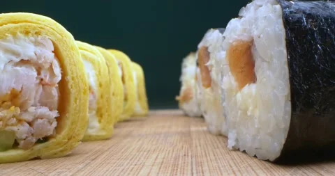 Extremely close-up, detailed. set of tamago maki and norimaki on wooden board Stock Footage 148886504