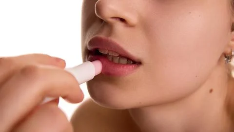 Extremely close up of female model applying, moisturizing, proactive lip balm on Stock Photos