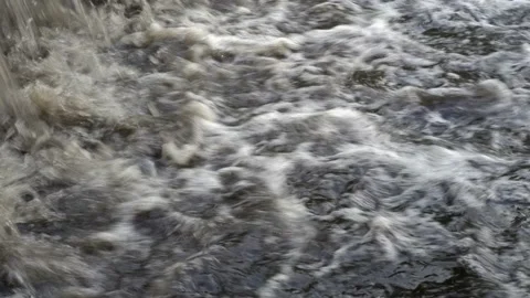 Extremely close up of the flow of muddy bubbling water rushing into the river 스톡 동영상 111722802
