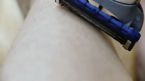 Extremely close-up Macro shot of razor blade Girl shave legs with razor closeup Stock Footage 130818719