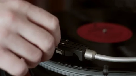 Extremely close-up male hand starting retro record player, lay down needle Stock Footage 129528643