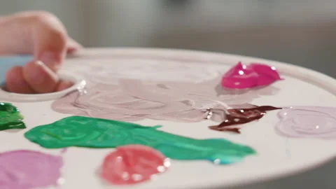 An extremely close-up of a paintbrush being dipped into pink acrylic paint by a Stock Footage 253485961