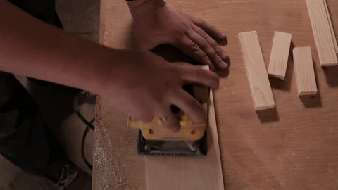 Extremely close shooting of manual grinding process in carpenter's hand. Stockbeeldmateriaal 110675541