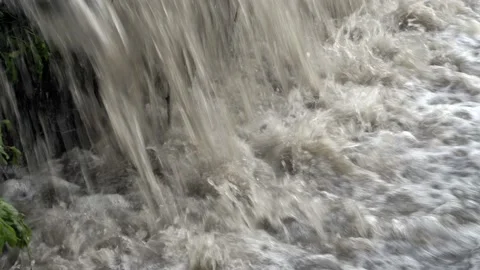 Extremely close-up of the turbulent flow of muddy bubbling water rushing 스톡 동영상 111716226