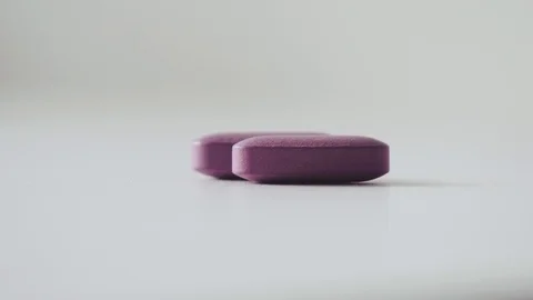 Extremely close-up of two lilac pills. medications during epidemics Stock Footage 111949624