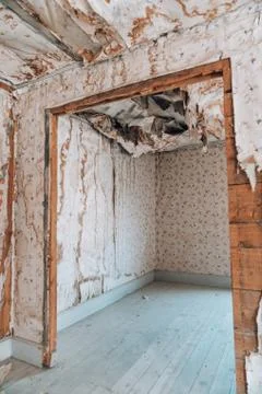 Extremely damaged wallpaper with collapsing ceiling, likely from water damage Stock Photos