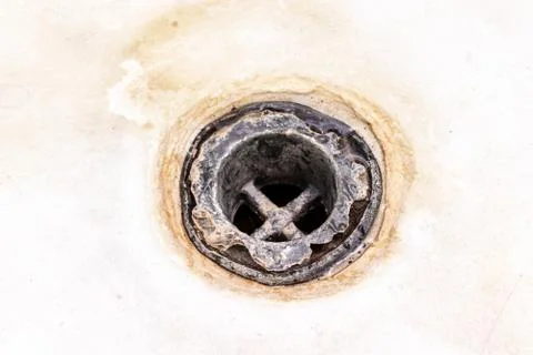 Extremely dirty bath drain mesh, hole covered with limescale or lime scale an Foto stock