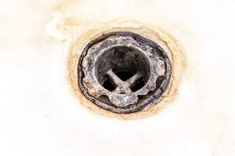Extremely dirty bath drain mesh, hole covered with limescale or lime scale an Stock Photos