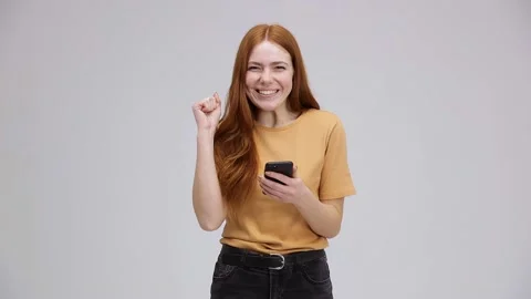 An extremely happy, contented girl is using her smartphone. The funny girl go Stock Footage 167304131