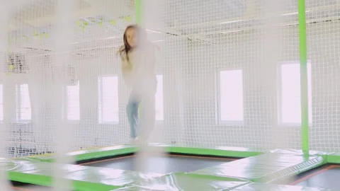 Extremely happy joyful girl jumping on trampoline in entertainment center Stock Footage 253417011