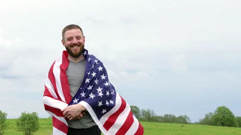 Extremely happy satisfied bearded man wrapped in American flag Stock Footage 154573463