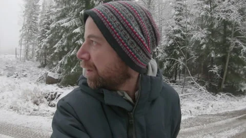 An extremely paranoid, frantic man walks along a snowy road, terrified of Stock Footage 146633885