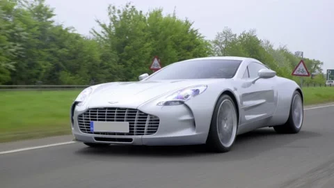 Extremely rare Aston Martin One-77 hypercar driving down a dual lane road Vidéo 145644374