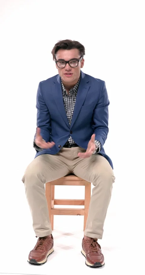 Extrovert young man with glasses in blue jacket talking and having a 스톡 동영상 310043779