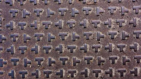 Extruded T-shaped patterns on dark metal Stock Photos