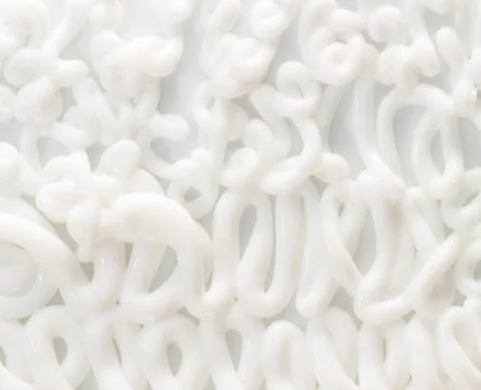 Extruded white moisturizing face or body cream on white background Stock Photos
