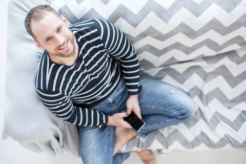 Exuberant nice man sitting on the couch Foto stock