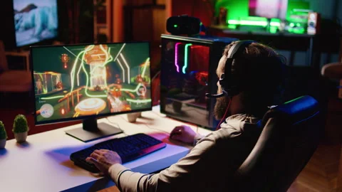 Exulting gamer jumping from joy after winning level in first person shooter Stock Footage 258304288