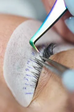 Eye close-up. The tweezers pull the lashes out to the sides when doing eyelash Stock Photos