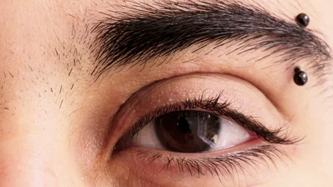 Eye, closeup and optometry with pupil for vision, eyebrow piercing and facial Video stock 334759982
