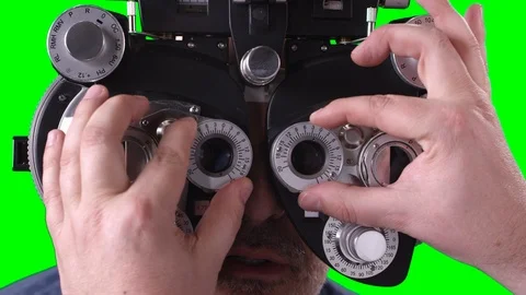 Eye Dr turning knobs on phoropter as man looks through it Video stock 107963828